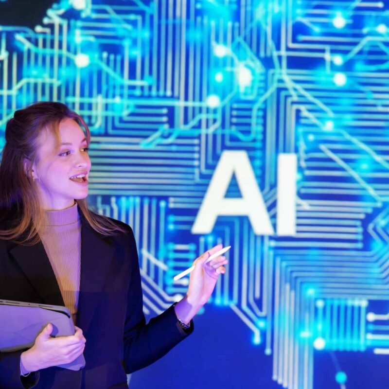 Confident speaker in a professional outfit presents artificial intelligence AI concepts at a technology conference